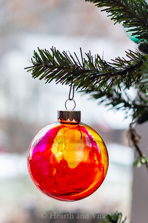 Alcohol ink ornament using canned air with colors of red, yellow, and magenta.