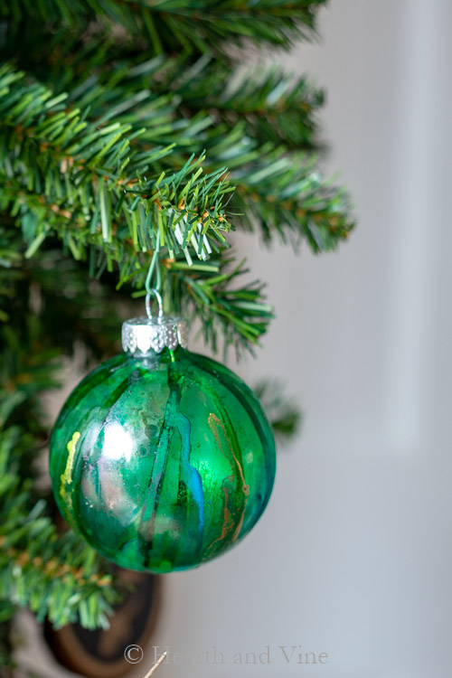 Green, blue and gold outside ornament on tree