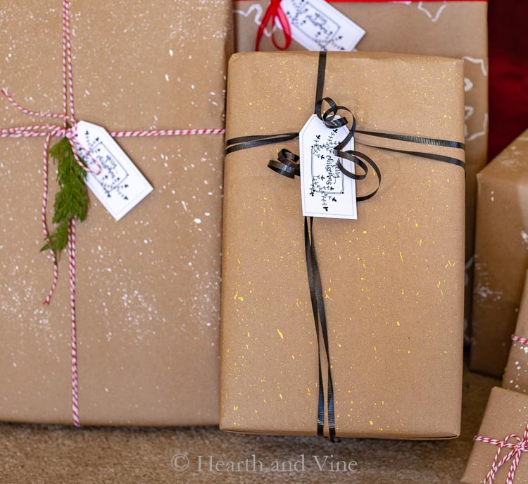 Gold splatter with black ribbon on kraft paper wrapped packages.
