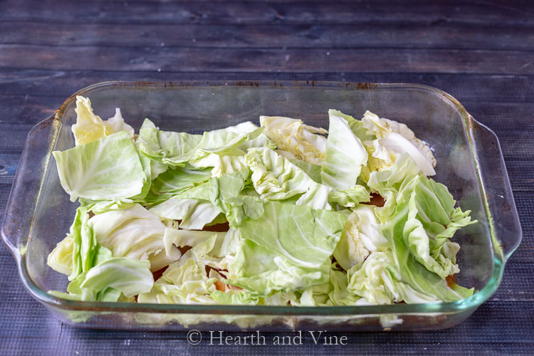 Cabbage pieces layered at bottom of casserole dish