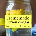 Mason jar with vinegar and citrus peels and a text overlay saying Homemade Lemon Vinegar for basic cleaning