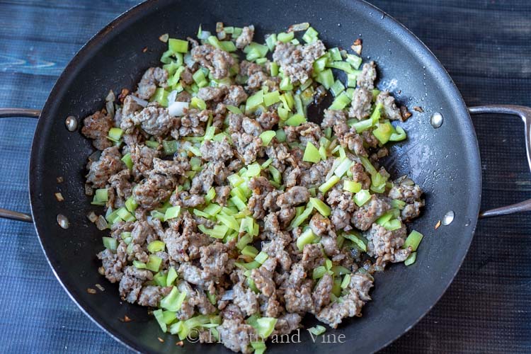 Italian sausage, banana peppers and onions in skillet