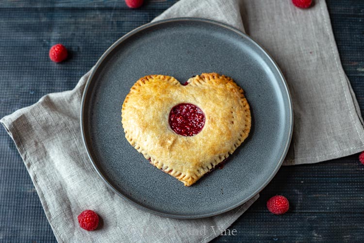 Heart shaped fresh raspberry pie on plate