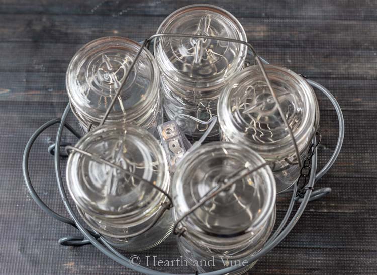 Five vintage mason jars in a basket.