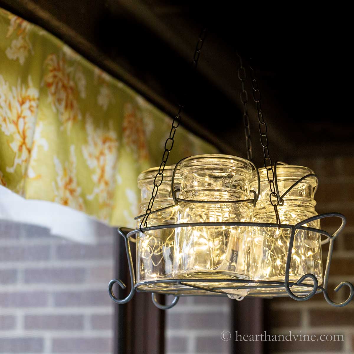 Vintage mason jars (5) in a wire basket with lights hanging like a chandelier.