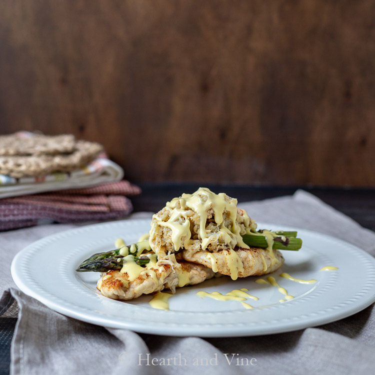 Chicken oscar on a plate. Two chicken breasts with asparagus, crabmeat and hollandaise sauce.