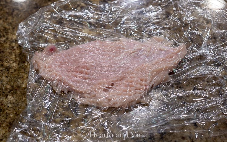 Pounded chicken breast on plastic