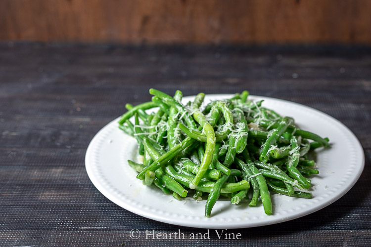 Plate of sauteed fresh green beans with garlic and Asiago cheese.