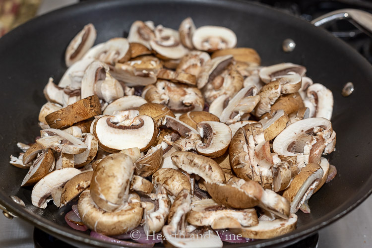 Sliced baby bella mushrooms in saute pan