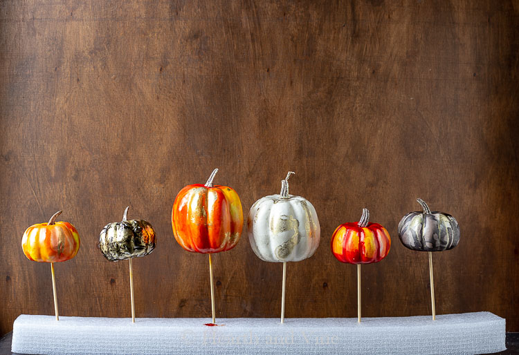 Alcohol ink pumpkins drying in a row