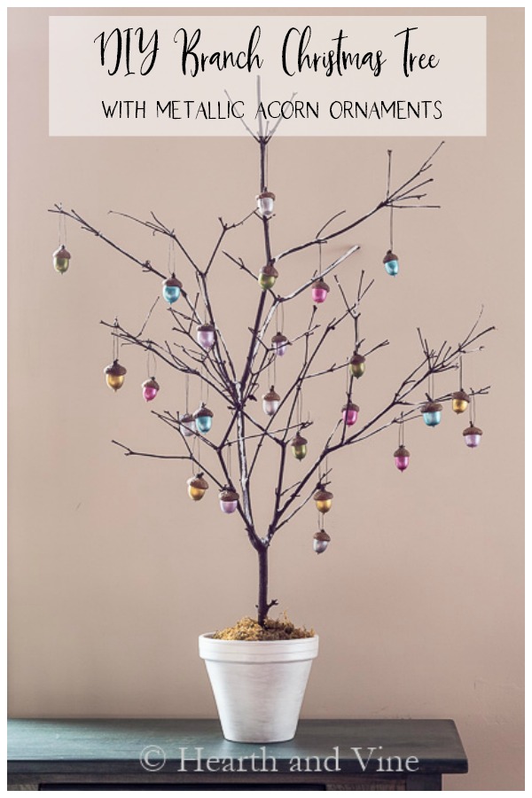 Christmas tree in pot from a branch with colorful acorn ornaments