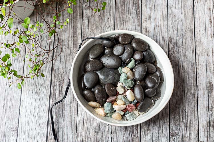 Small indoor water fountain with black stones and colored rocks