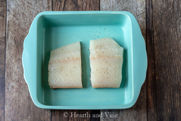 Raw halibut fillets in a baking dish