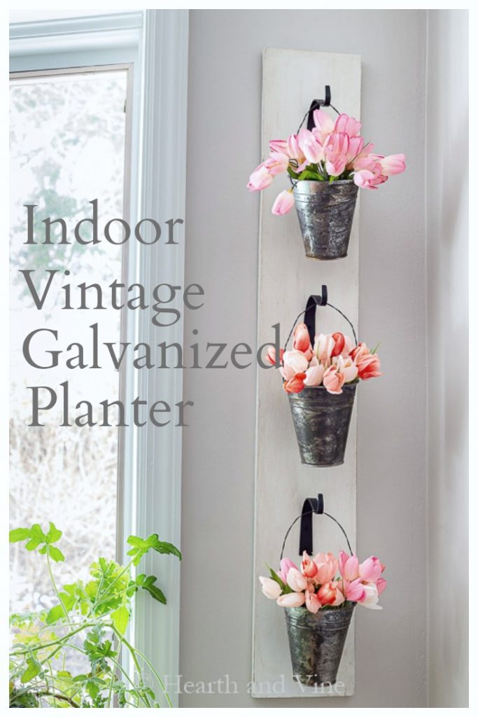 Hanging wall planter with galvanized pails filled with artificial tulips