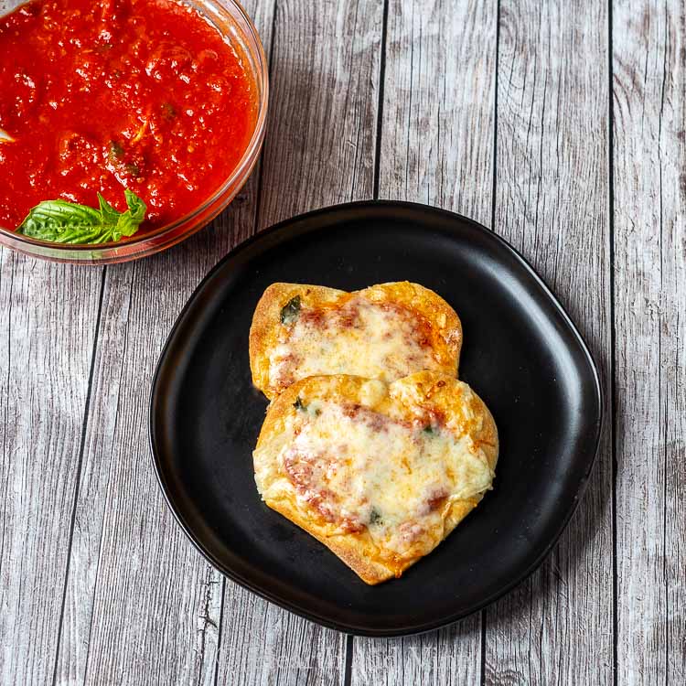 Two mini heart shaped pizzas on a plate