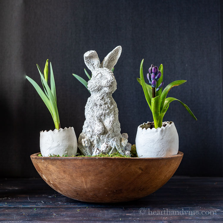 Cement bunny and clay eggs with flowers in vintage dough bowl