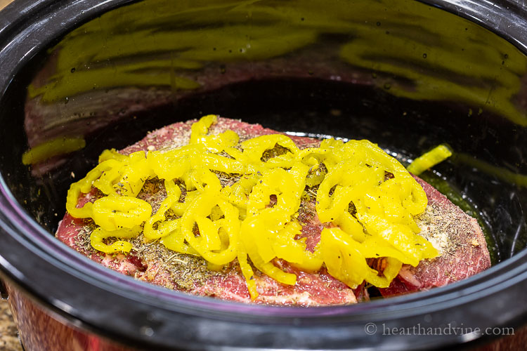 Mild pepper rings on top of chuck roast in slow cooker