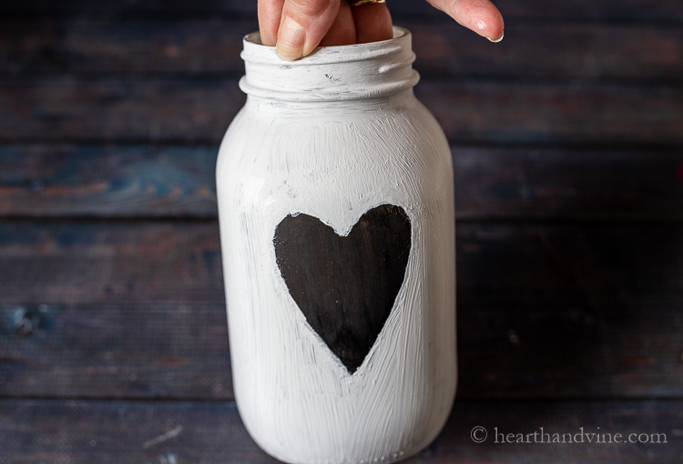 Black heart with white paint on jar