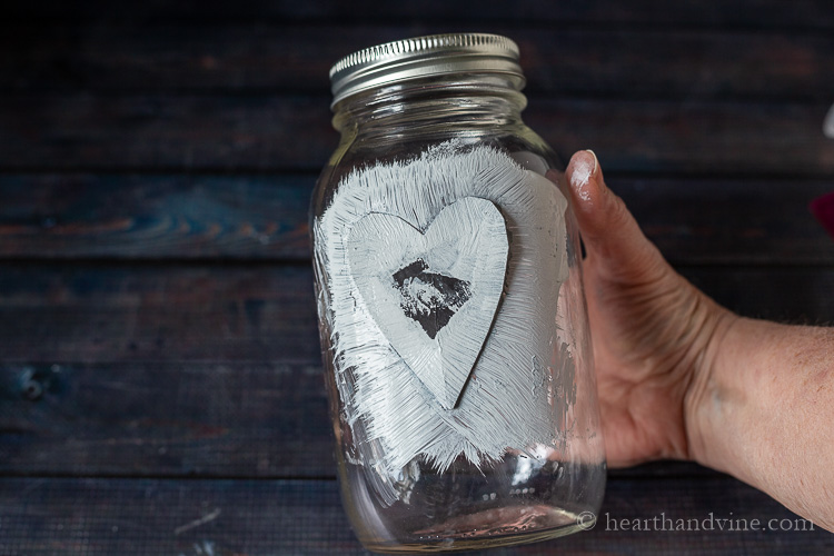 White paint over heart on jar