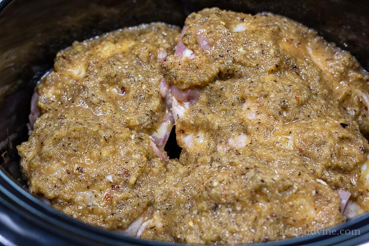 Chicken pieces topped with jerk marinade in a crockpot