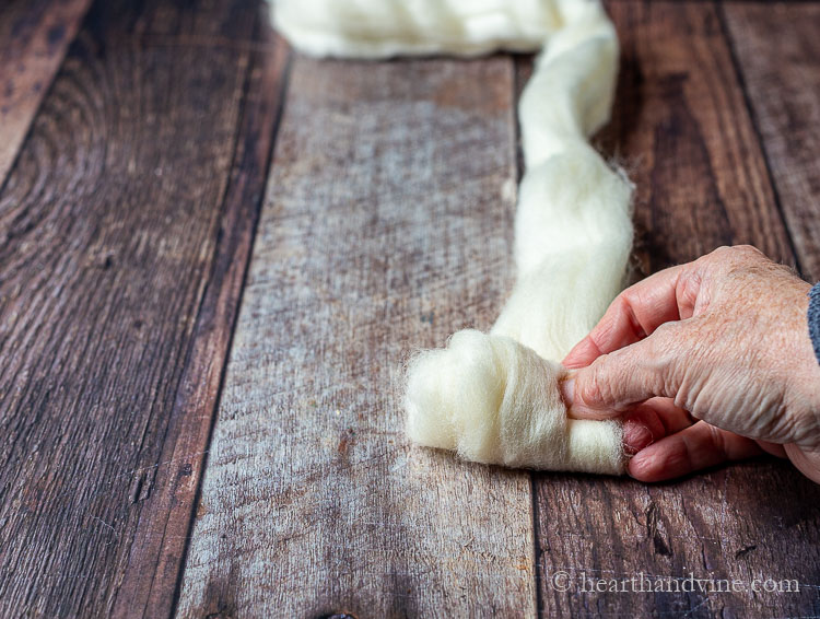 Rolling a piece of natural wool roving into a ball