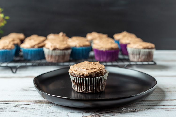 Sour cream chocolate cupcake with chocolate buttercream frosting o a plate.