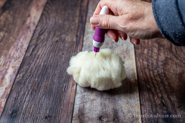 Using a felting pen to combine wool roving fibers together.