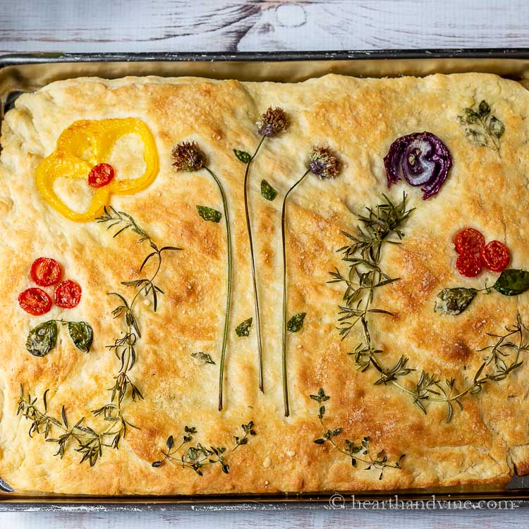 Close up of focaccia with flower vegetables on top.