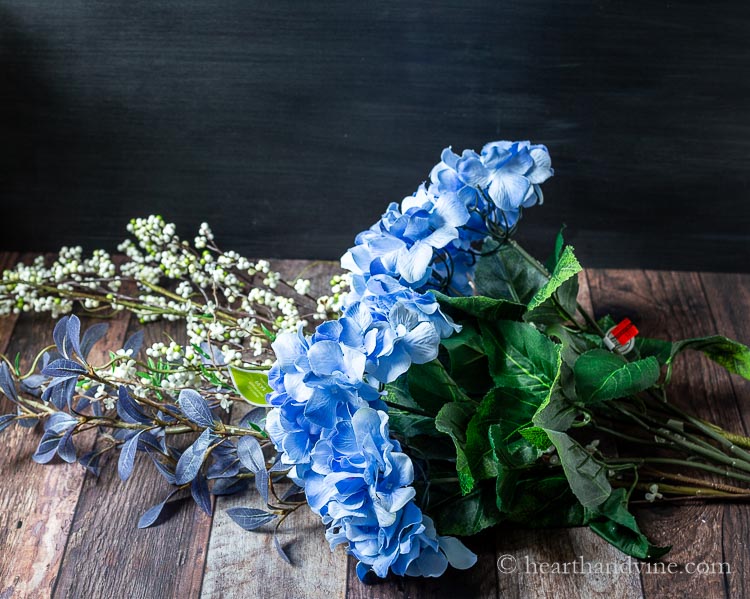 Artificial blue hydrangea flowers and other long stemmed branches. 