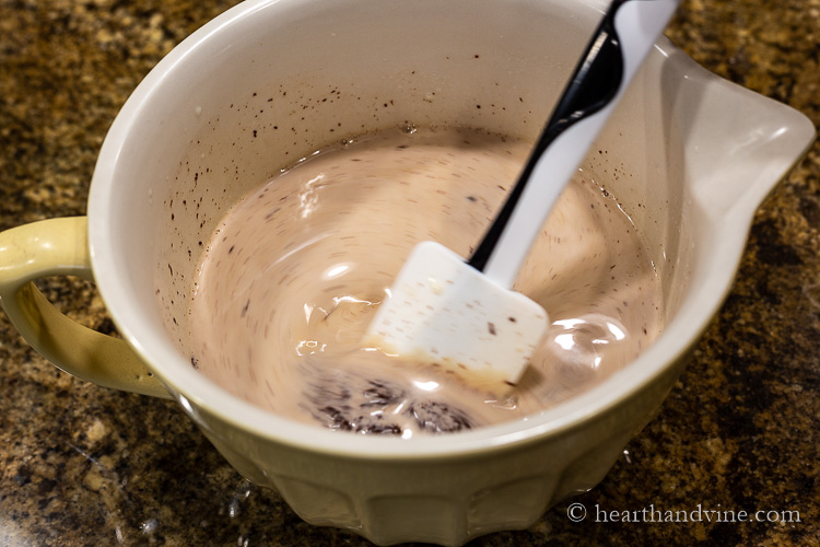 Mixing chocolate with heated cream.