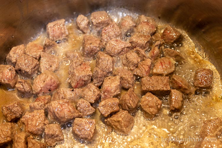 Browning beef in a large pot with garlic.