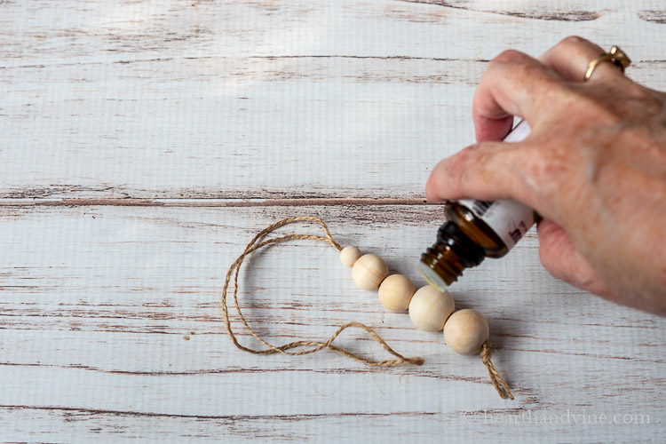 Placing drops of essential oil on wood beads.