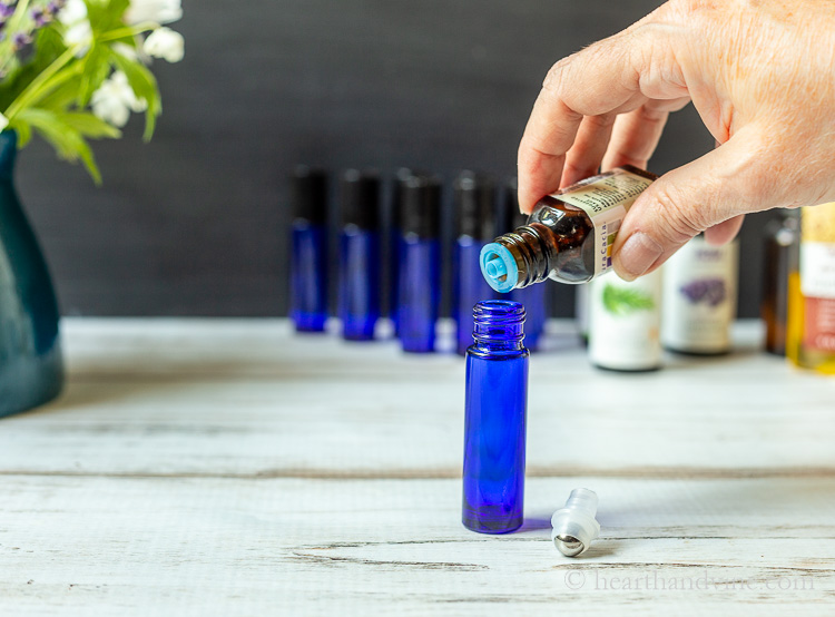 Essential oils poured into colbalt blue roller bottle