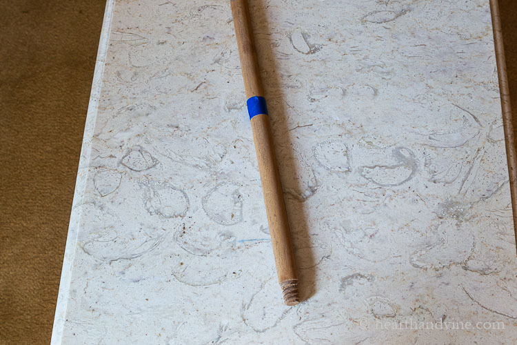 Old broom stick with blue tape near the end.