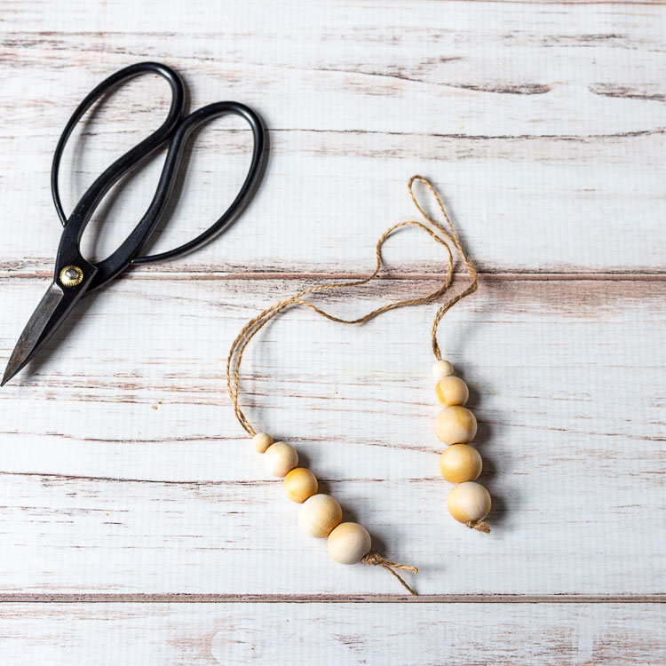 Two wood bead diffusers and a pair of scissors