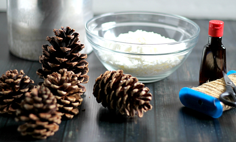 Supplies for scented pine cones including soy wax, pumpkin spice extract, pine cones and a wax pitcher.