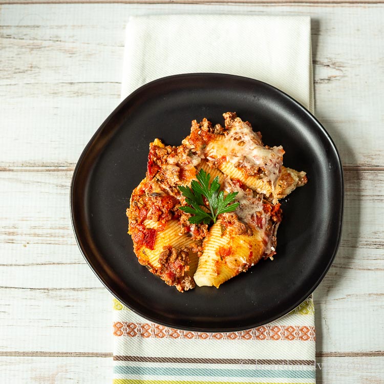 Plate of stuffed shells with meat sauce.