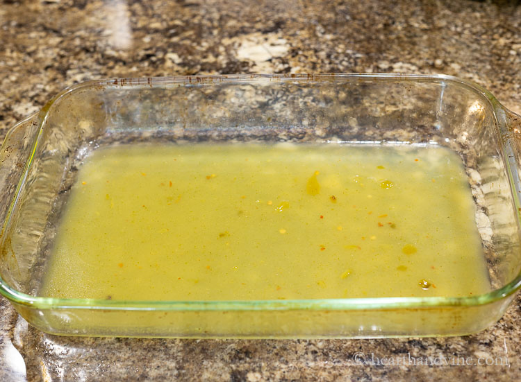 Green enchilada sauce in bottom of pan.