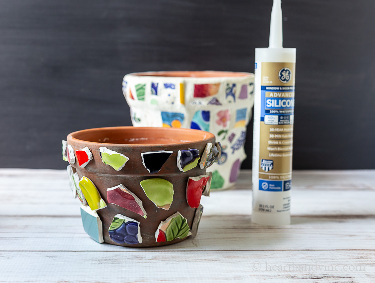 Silicon tube and clay pot with broken pieces of ceramics glued on.