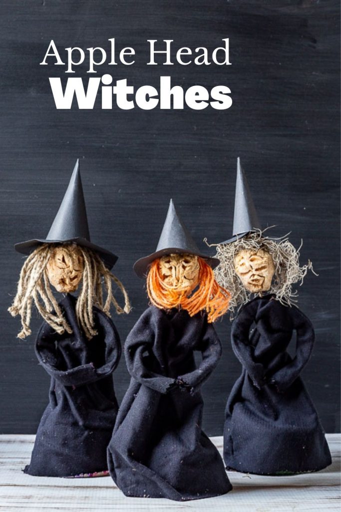 Three witches made from dried carved apples for heads, paper hats and black fabric dresses.