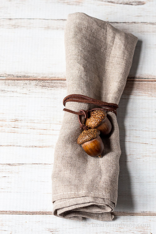 Linen tied with an acorn napkin tie made up of two real similar sized acorns and brown suede cording.