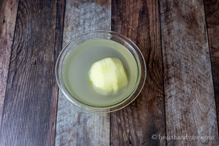 Apple head sitting in some lemon water.