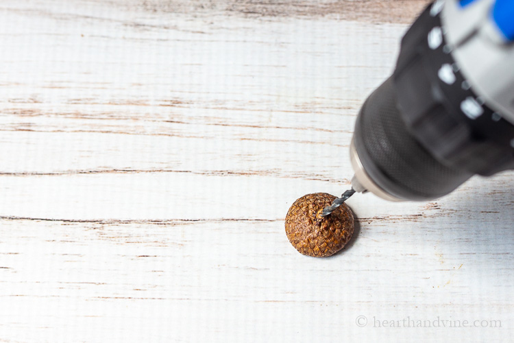 Drilling a hole in an acorn cap.