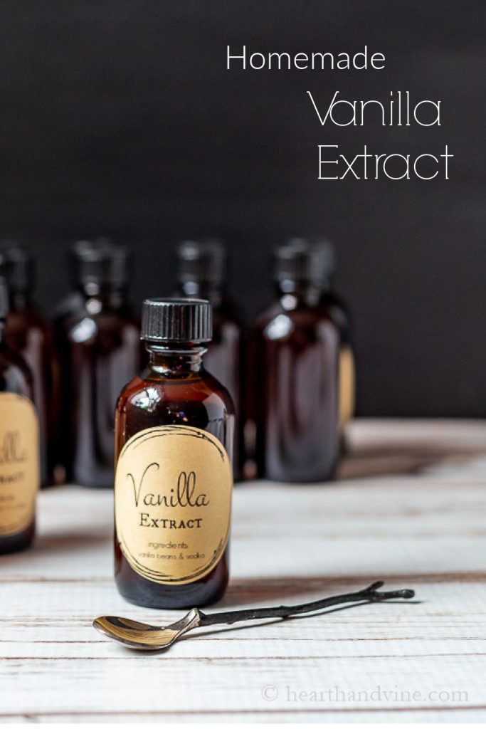 A bottle of homemade vanilla extract next to a branch handled decorative spoon.