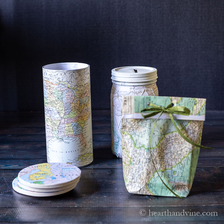 Four different crafts made with maps. Coaster, candle, bank and bag.