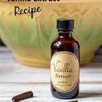 Homemade bottle of vanilla extract in front of a yellow and green mixing bowl