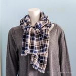 Blue black gray and white plaid flannel scarf on a mannequin