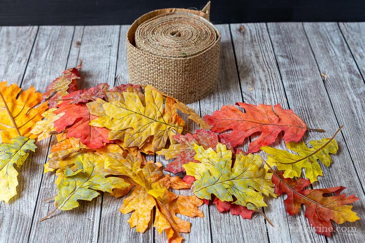 Burlap ribbon next to some faux fall leaves.