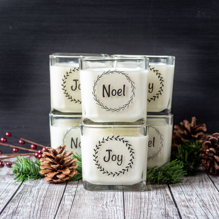 Stacked Christmas candles with packing tape labels containing the words Noel and Joy.