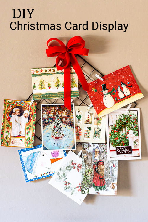 Christmas card holder with red bow and mini clothespins fill with Christmas cards.